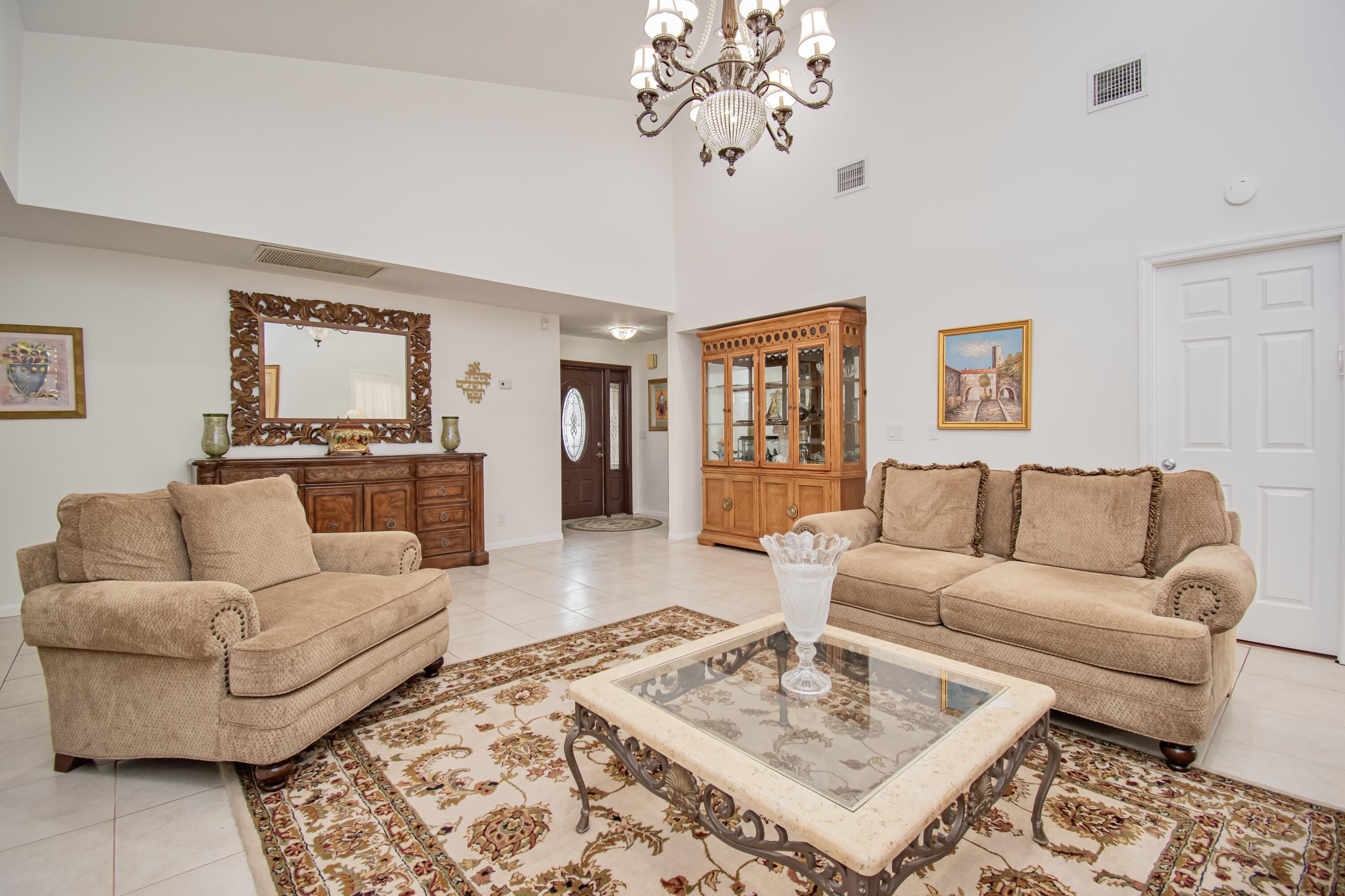 7838 Cypress Crescent Boca Raton, FL 33433 - Photo 4 of 24 a living room with furniture a rug and a chandelier