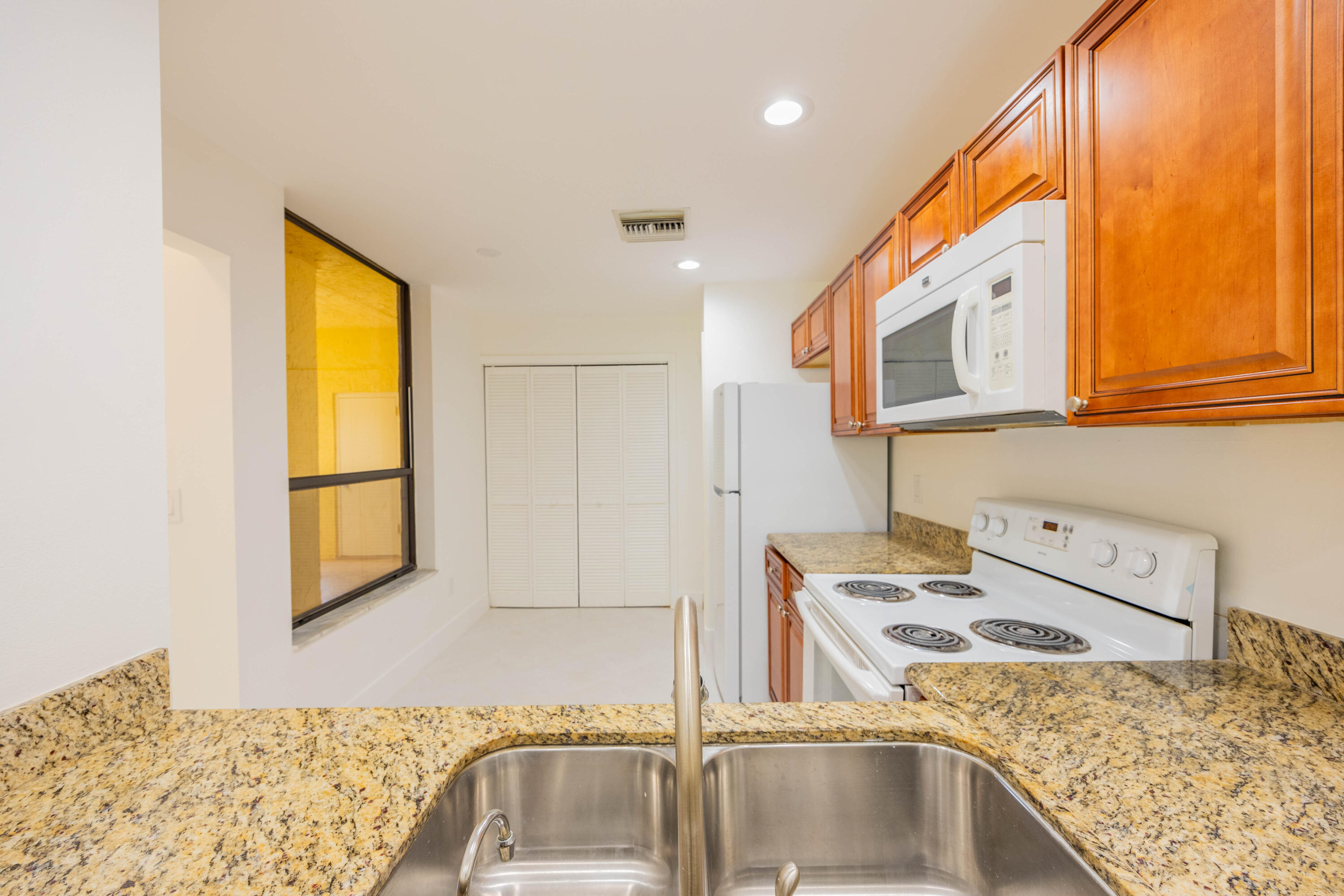 7520 La Paz Boulevard, Unit 104 Boca Raton, FL 33433 - Photo 16 of 56 a kitchen with stainless steel appliances granite countertop a sink and a stove