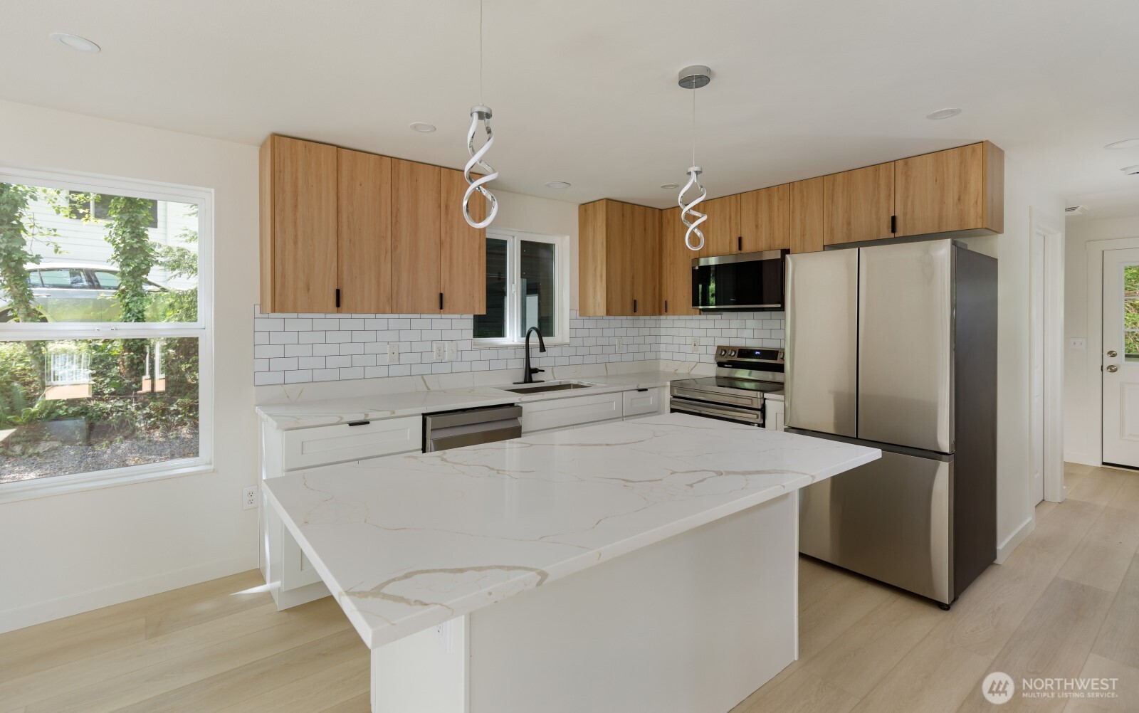 7605 Northeast Hidden Cove Road Bainbridge Island, WA 98110 - Photo 29 of 36 a kitchen with stainless steel appliances a refrigerator stove microwave and sink