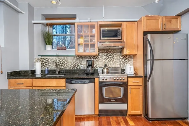 a kitchen with granite countertop a refrigerator a stove a washer and dryer
