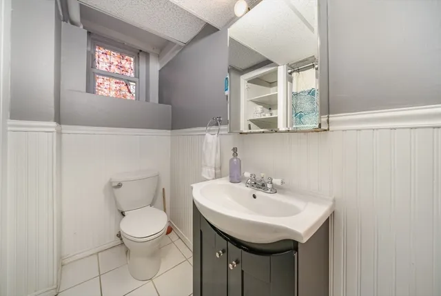 a bathroom with a sink toilet and a mirror