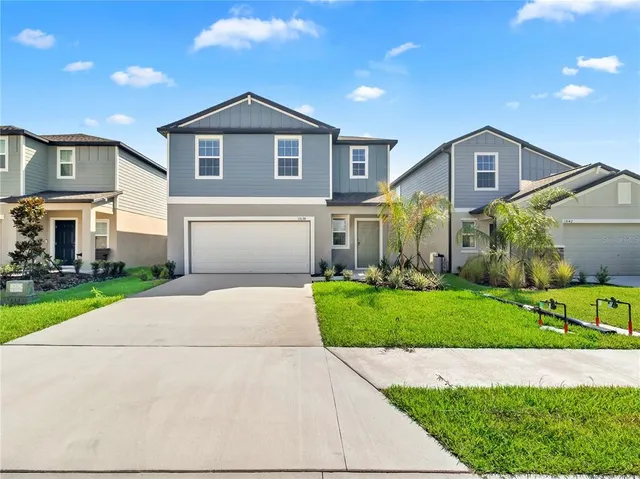 a front view of a house with a yard and garage