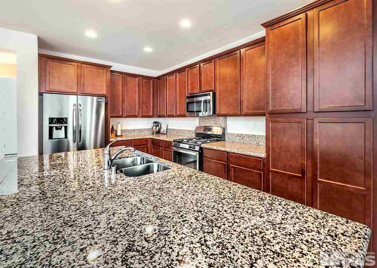 2045 Hope Valley Drive Reno, NV 89521 - Photo 5 of 20 a kitchen with stainless steel appliances granite countertop a refrigerator a stove and a sink with wooden floor