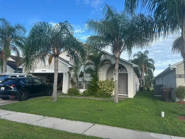 a front view of a house with a garden and trees