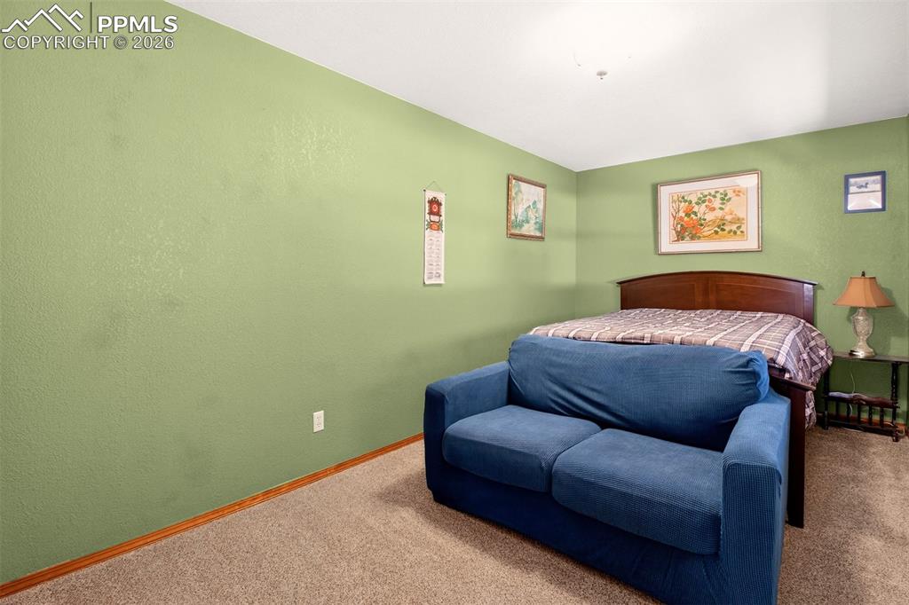 1445 Sutherland Creek Road Manitou Springs, CO 80829 - Photo 28 of 43 a bedroom with a bed and a couch