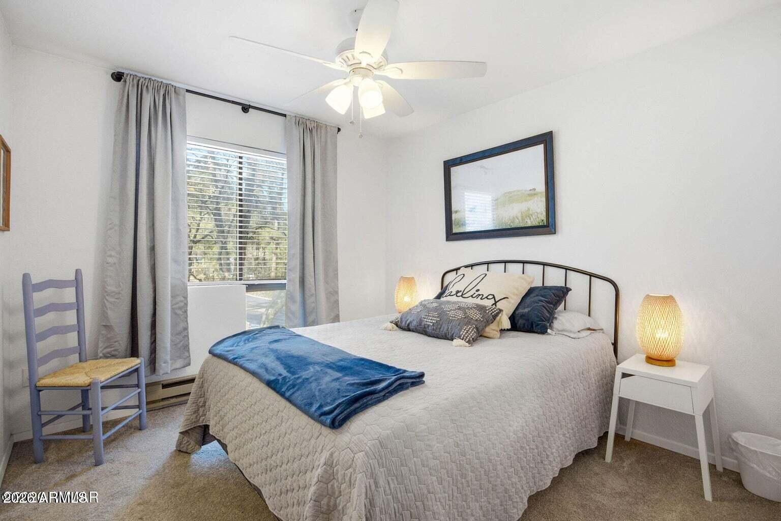 2700 South White Mountain Road, Unit 404 Show Low, AZ 85901 - Photo 12 of 20 a bedroom with a bed and a chandelier
