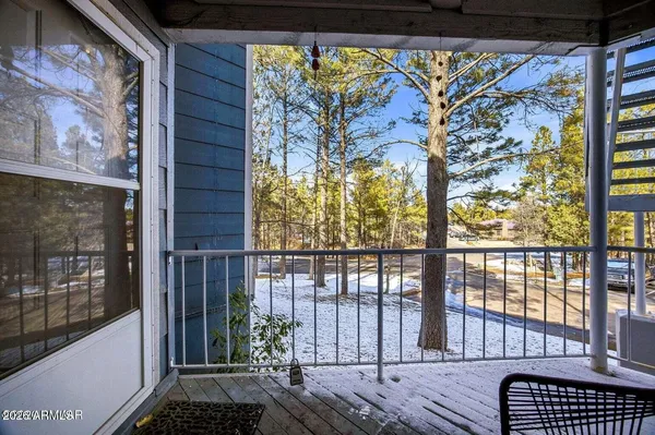 a view of a balcony with wooden floor and iron fence