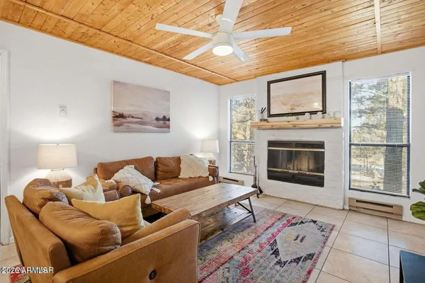 a living room with furniture a flat screen tv and a fireplace