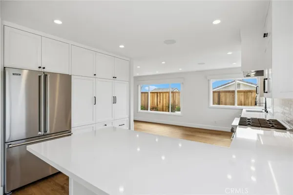 a view of a kitchen with refrigerator and white cabinets