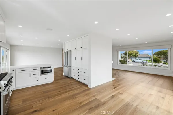 an empty room with furniture and a kitchen view