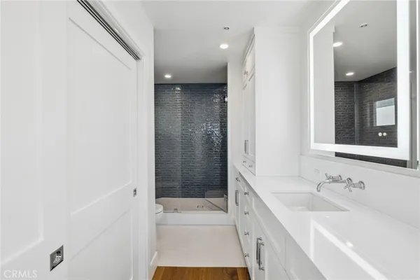 a bathroom with a sink a toilet and shower