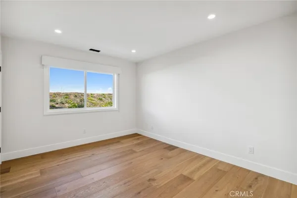 an empty room with wooden floor and window