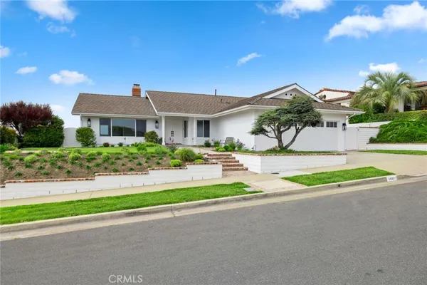 a front view of a house with a yard and potted plants