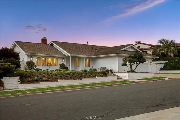 a front view of a house with a garden and a yard