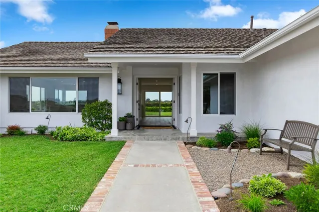 a view of a house with potted plants and a table