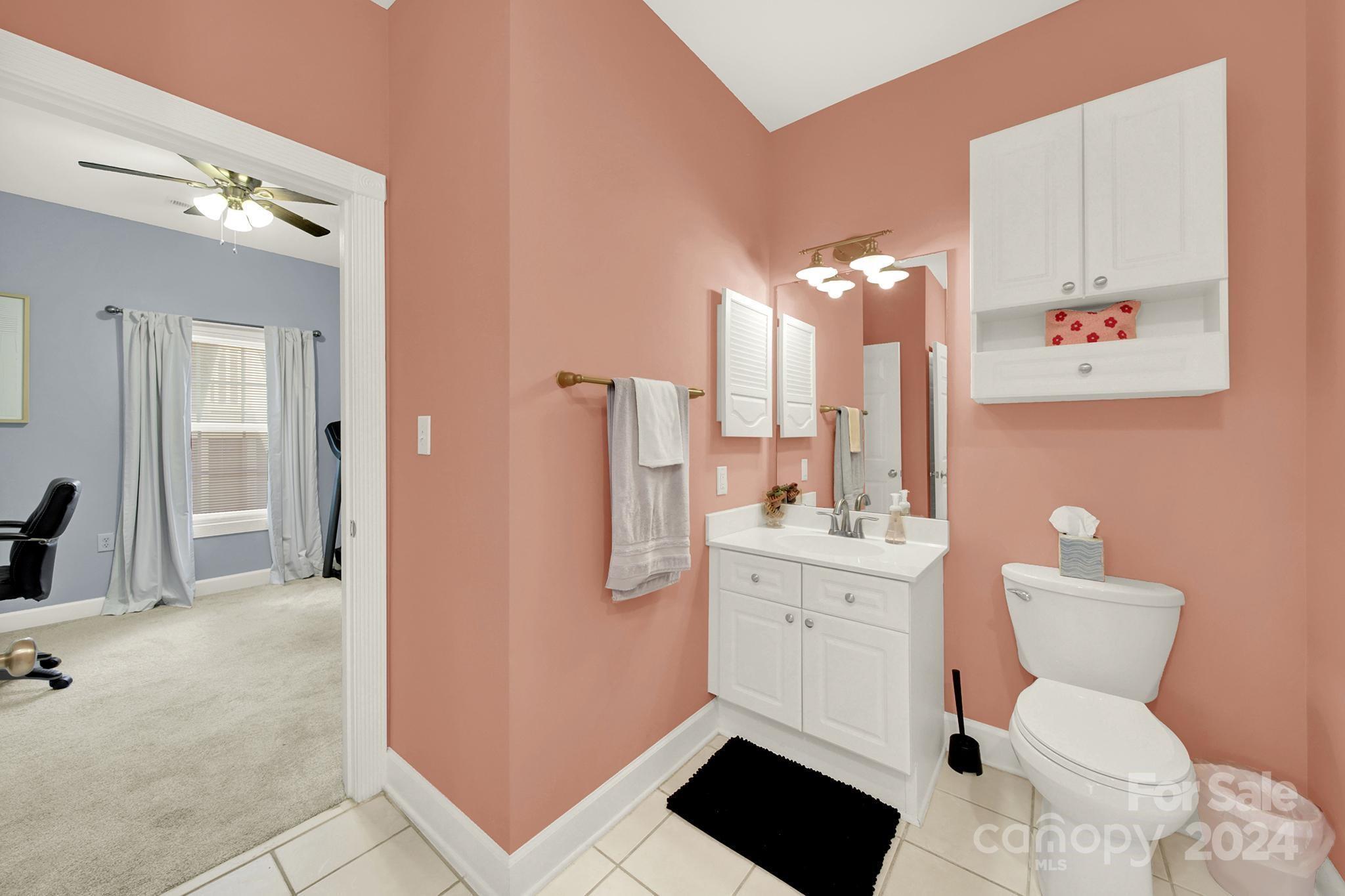 8959 Meadow Vista Road Charlotte, NC 28213 - Photo 12 of 32 a bathroom with a toilet sink and mirror