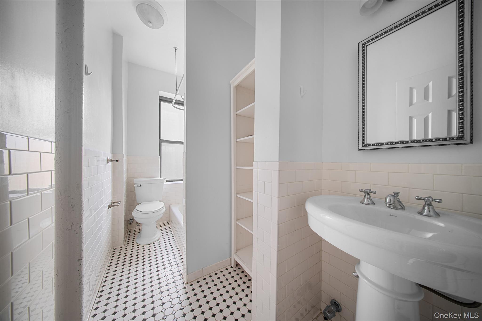 779 Riverside Drive, Unit C63/C64 Manhattan, NY 10032 - Photo 10 of 16 a bathroom with a sink a toilet and a mirror
