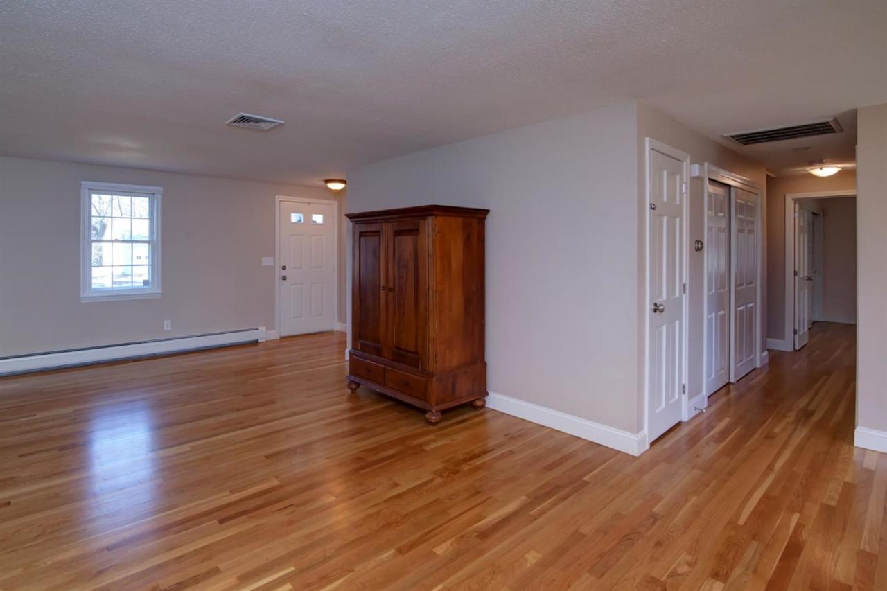 140 Ansel Howland Road Centerville, MA 02632 - Photo 11 of 26 an empty room with wooden floor and windows