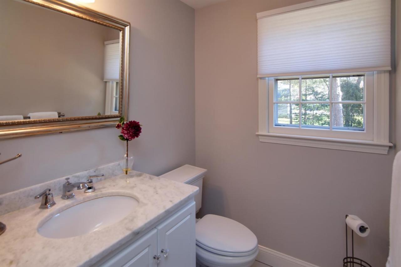 140 Ansel Howland Road Centerville, MA 02632 - Photo 17 of 26 a bathroom with a granite countertop sink a toilet and a mirror