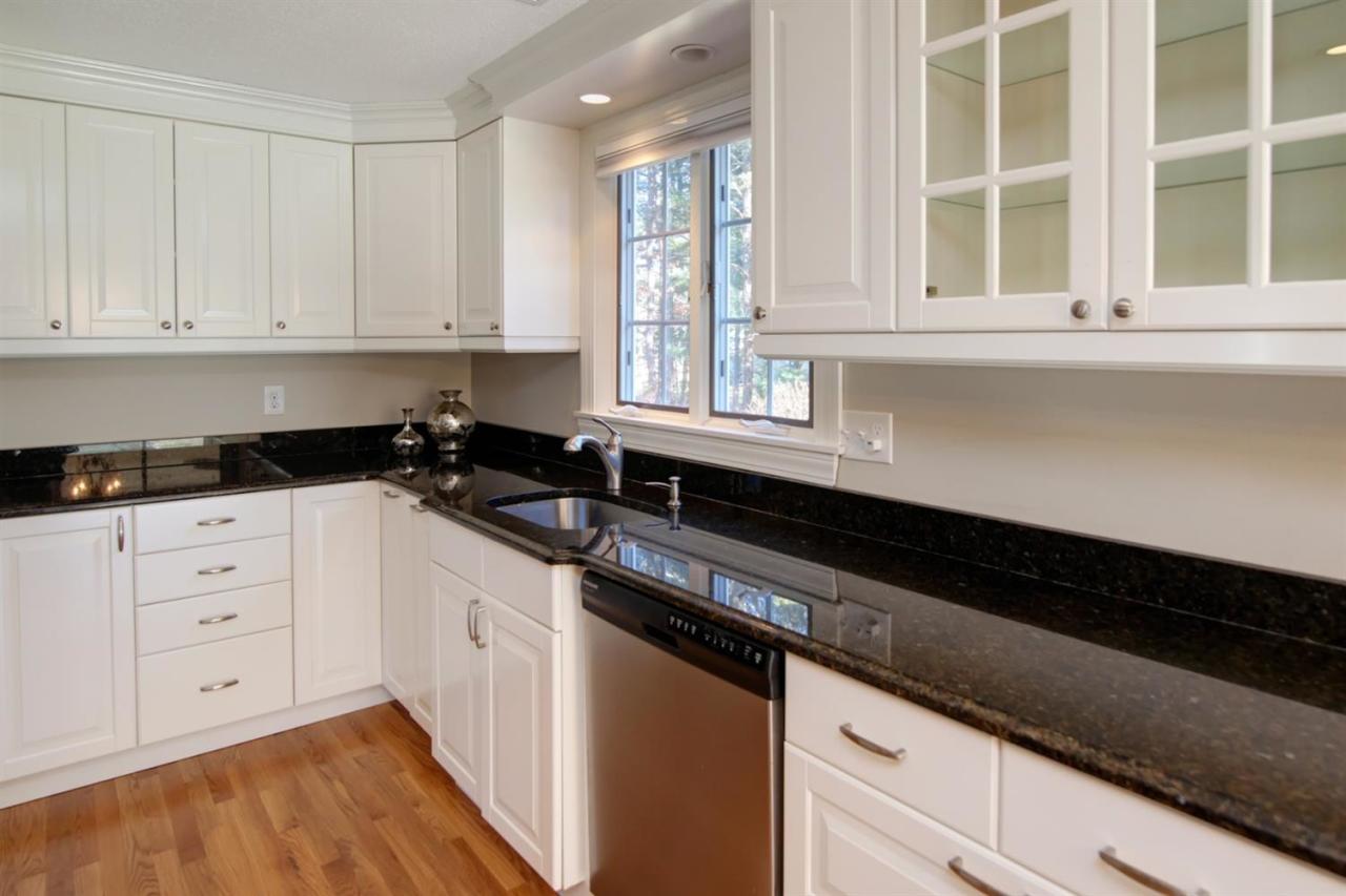 140 Ansel Howland Road Centerville, MA 02632 - Photo 4 of 26 a kitchen with granite countertop white cabinets and black appliances