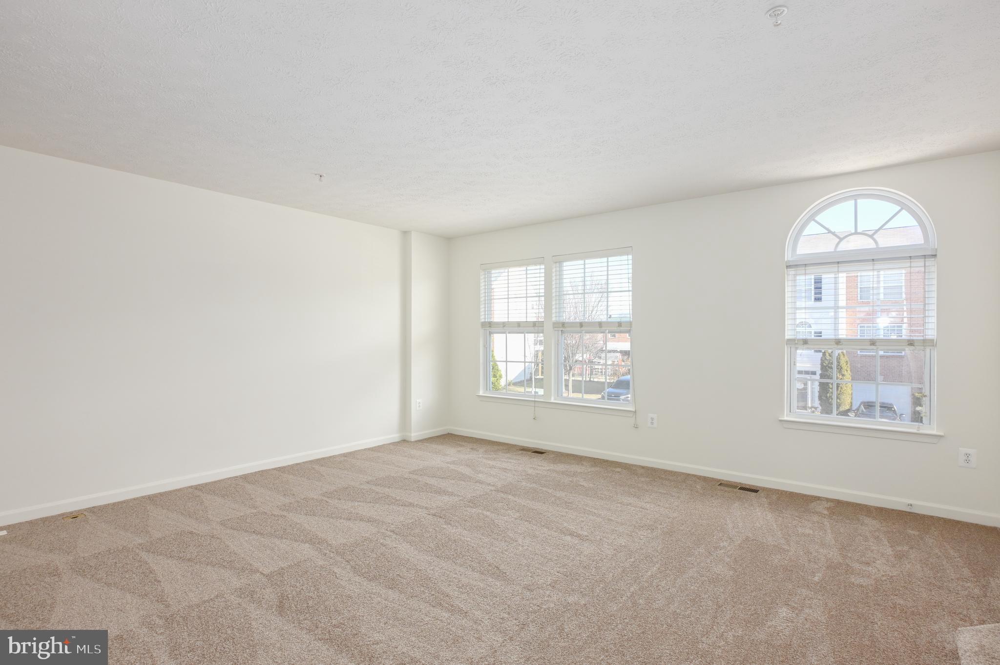 9871 Decatur Road Baltimore, MD 21220 - Photo 19 of 31 an empty room with wooden floor and windows