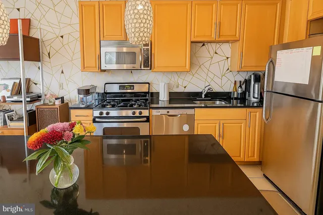 a kitchen with stainless steel appliances granite countertop a stove a sink and a refrigerator