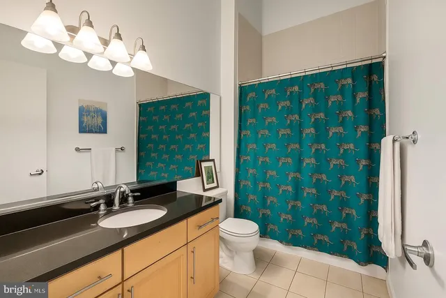 a bathroom with a sink a toilet a mirror a vanity and window