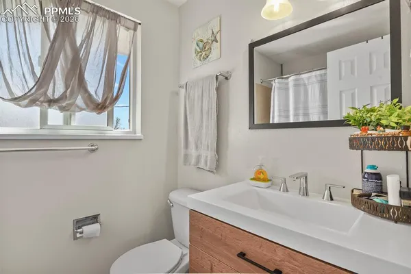 a bathroom with a sink a toilet and mirror