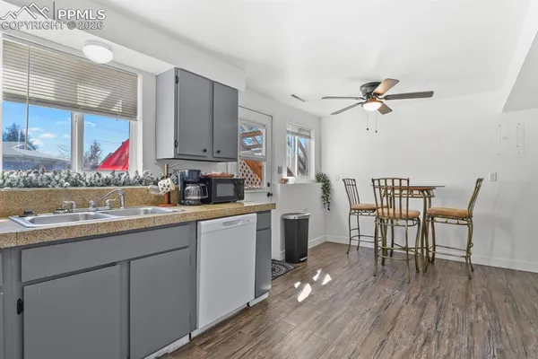 a kitchen with a table chairs and white cabinets