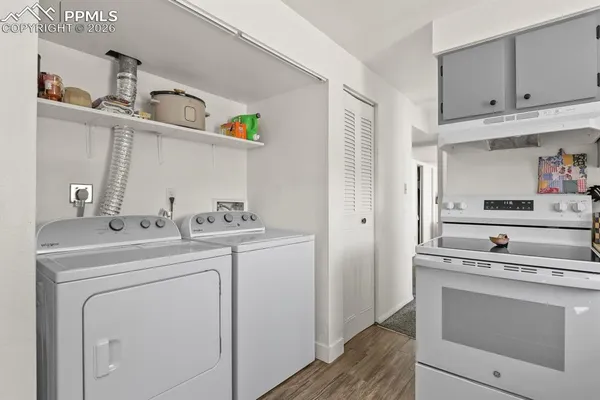 a kitchen with a stove cabinets and wooden floor