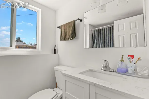 a bathroom with a toilet sink and mirror