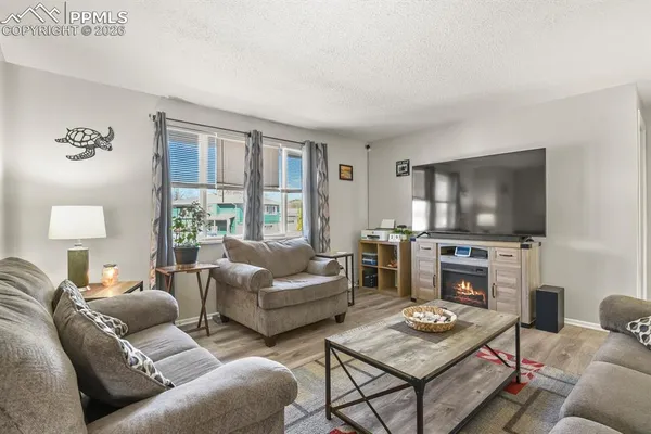 a living room with furniture a flat screen tv and a large window