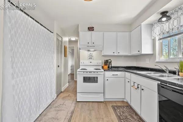 a kitchen with a white stove top oven and white cabinets