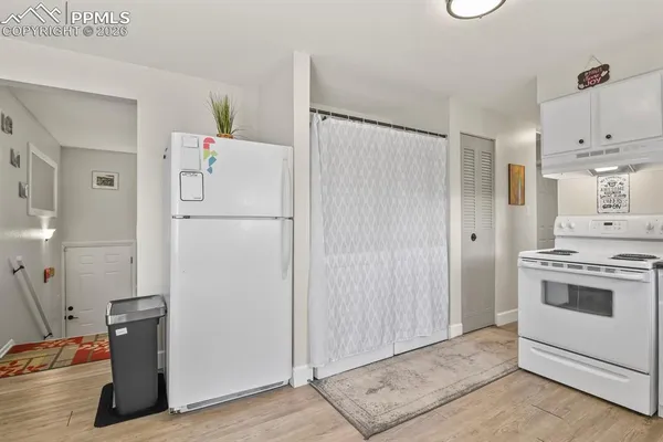 a white refrigerator freezer and a stove sitting inside of a kitchen