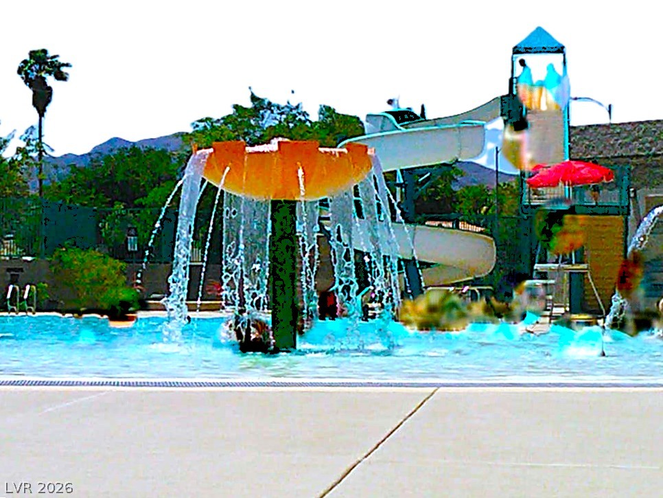 1140 Julie Road Henderson, NV 89002 - Photo 34 of 38 A refreshing aquatic playground with a vibrant water feature and thrilling slides awaits.