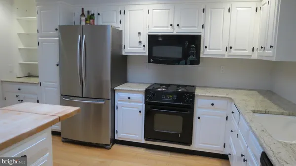 a kitchen with stainless steel appliances granite countertop a refrigerator stove and microwave