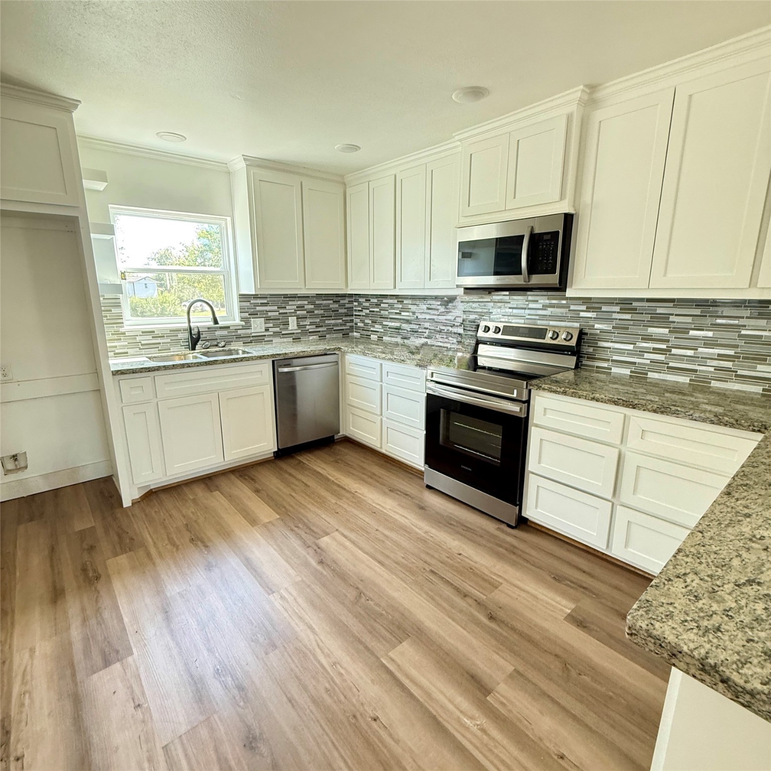 143 Bastrop Bayou Drive Angleton, TX 77515 - Photo 20 of 32 a kitchen with granite countertop a sink cabinets and stainless steel appliances