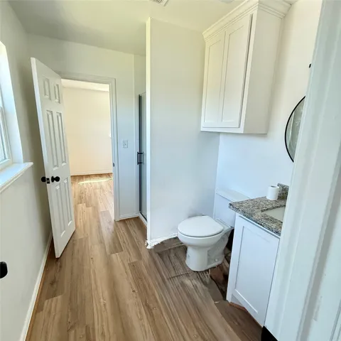 a bathroom with a granite countertop toilet sink and a mirror