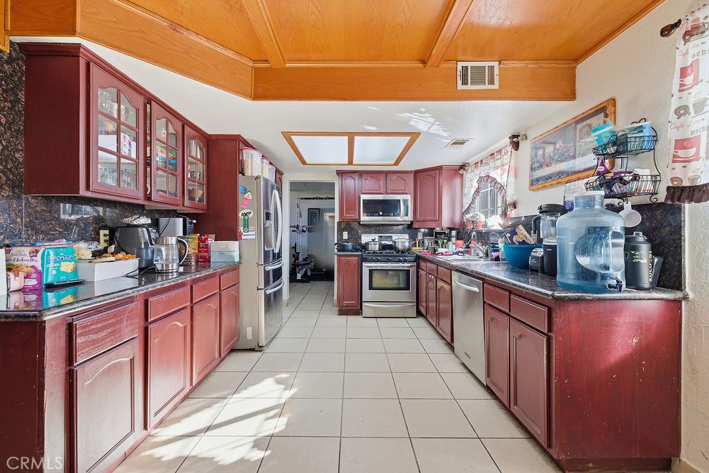 5390 Karling Place Palmdale, CA 93552 - Photo 25 of 36 a kitchen with stainless steel appliances granite countertop a stove top oven a sink dishwasher and cabinets