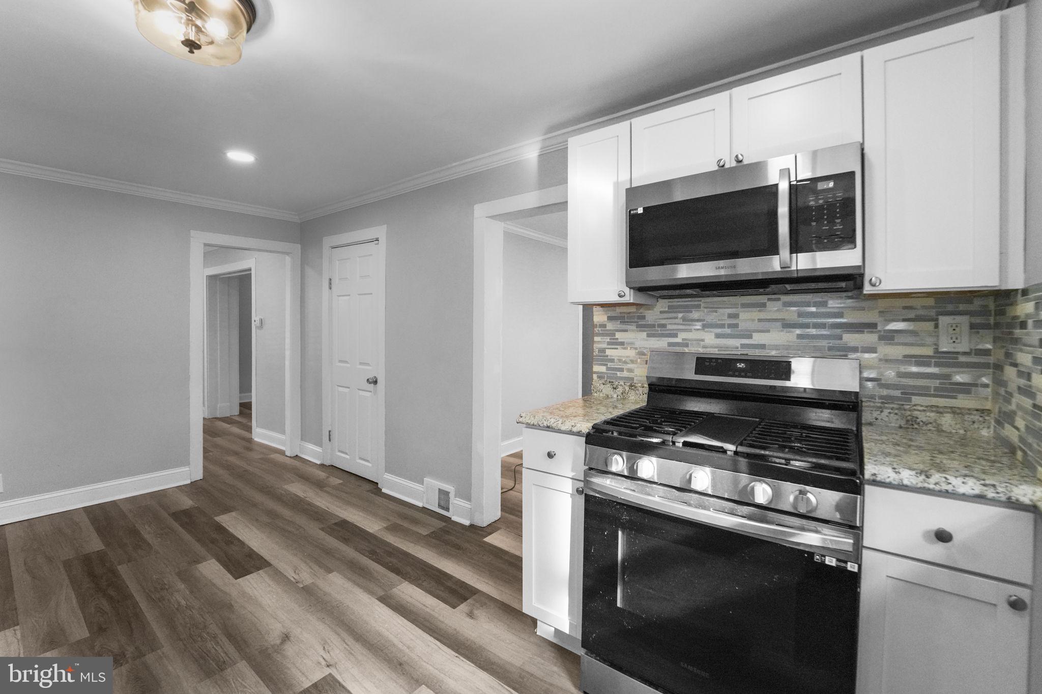 2652 South Main Road Vineland, NJ 08360 - Photo 21 of 44 a kitchen with granite countertop a stove and a microwave