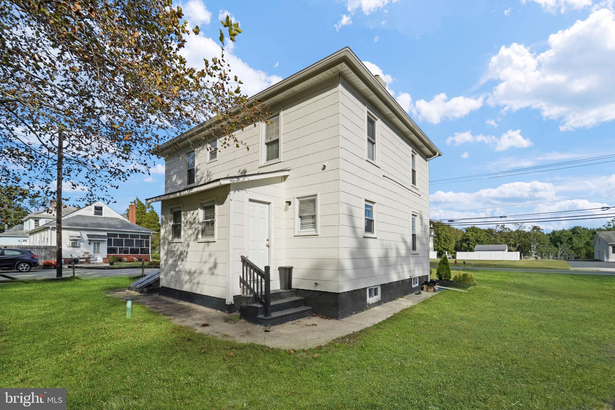 2652 South Main Road Vineland, NJ 08360 - Photo 7 of 44 a view of a white house with a big yard and large trees