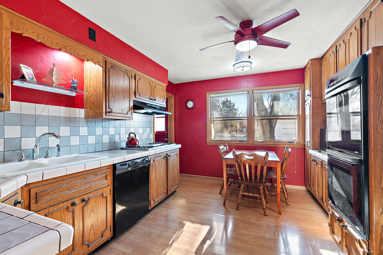 1423 Hillview Road Homewood, IL 60430 - Photo 11 of 23 a kitchen with stainless steel appliances granite countertop a stove top oven a sink dishwasher a dining table and chairs with wooden floor
