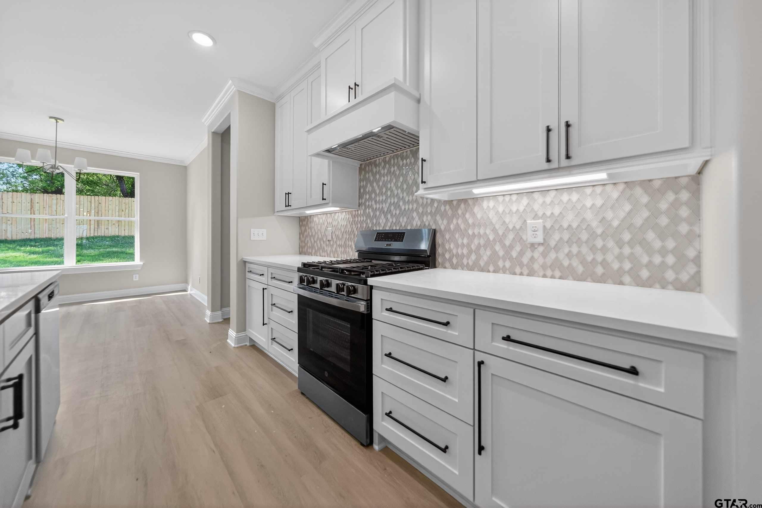 3049 Guinn Farms Road Tyler, TX 75707 - Photo 11 of 43 a kitchen with granite countertop a stove and a wooden floors