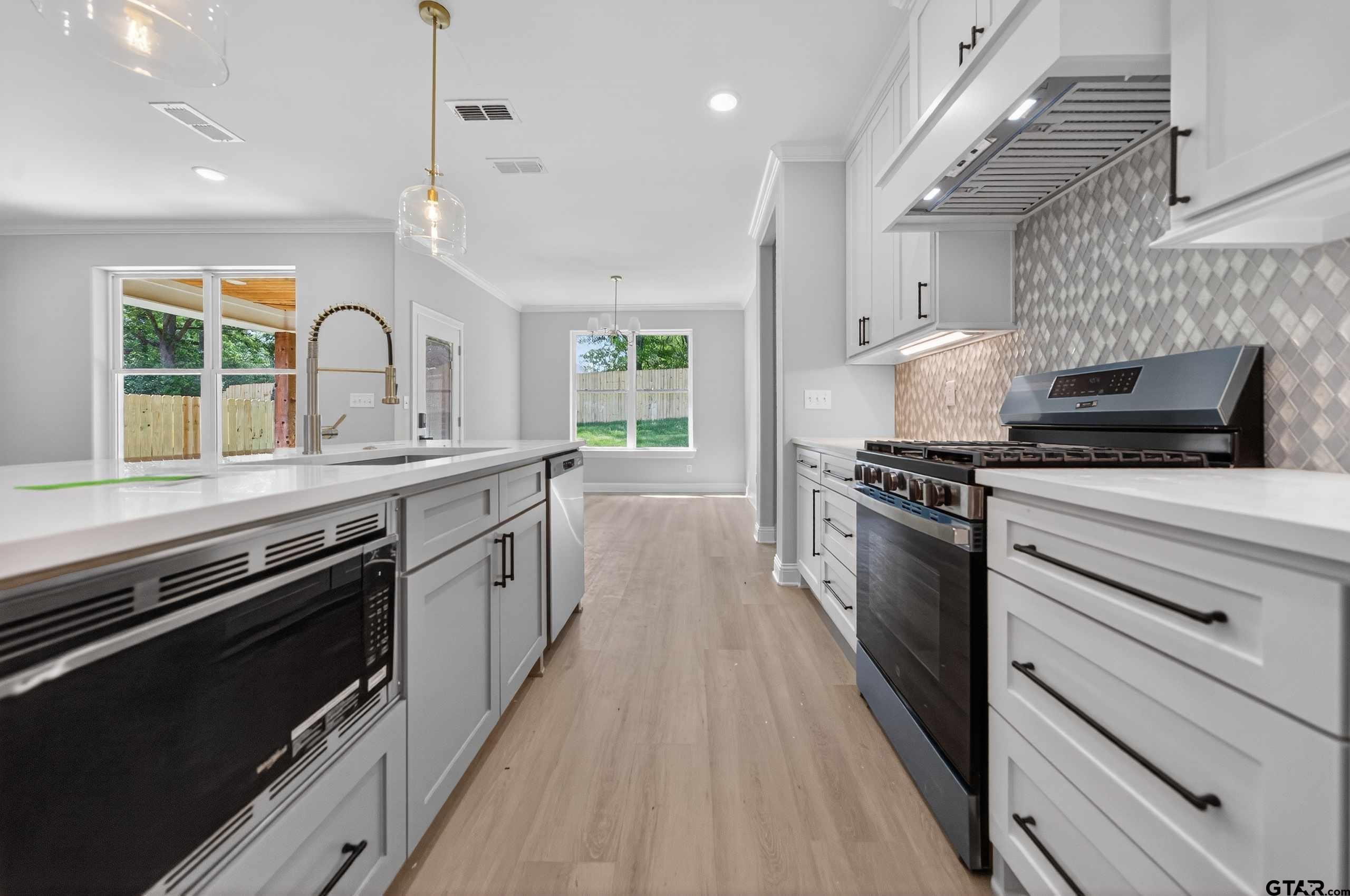 3049 Guinn Farms Road Tyler, TX 75707 - Photo 13 of 43 a kitchen with stainless steel appliances a stove sink and cabinets