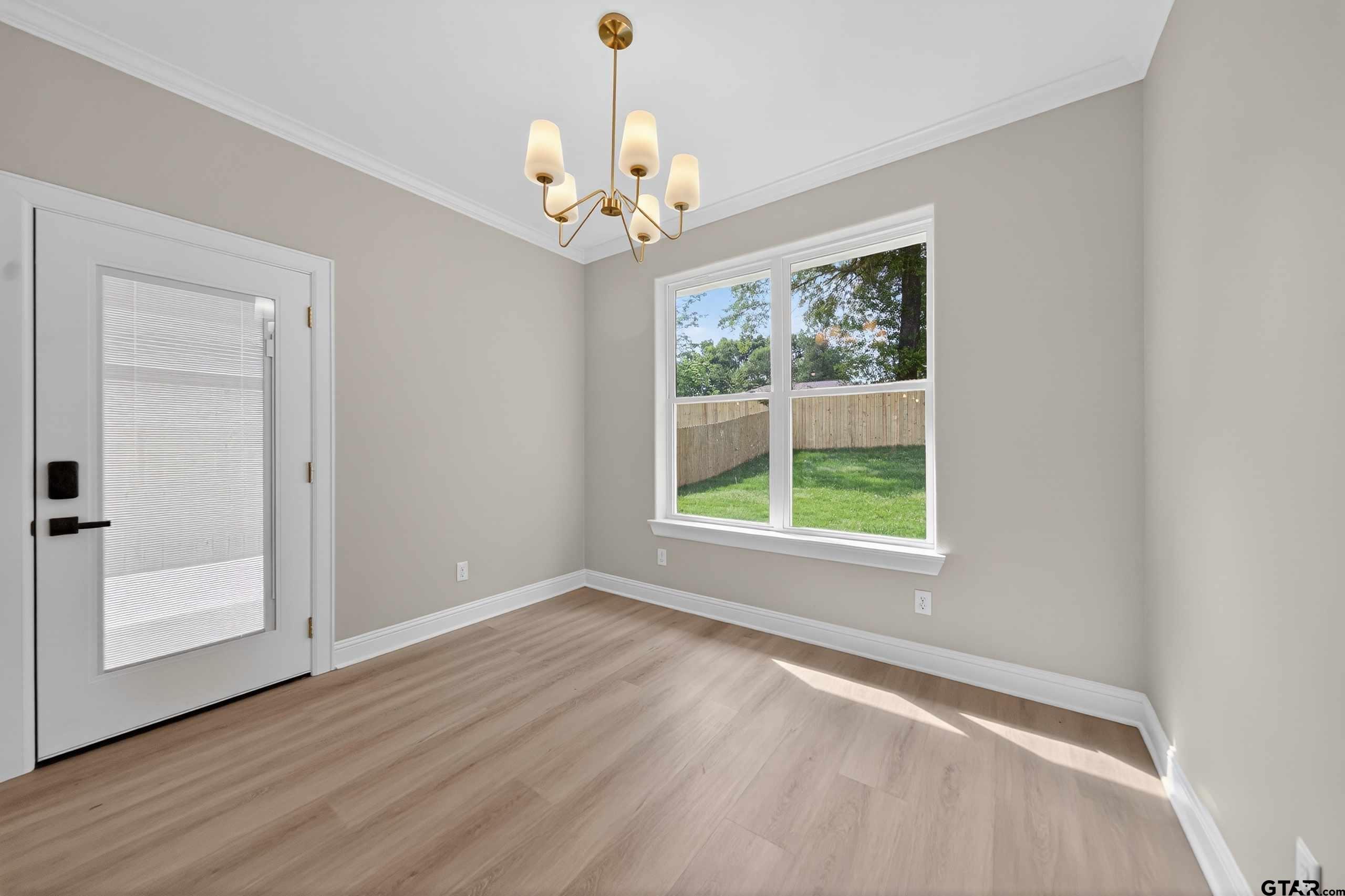 3049 Guinn Farms Road Tyler, TX 75707 - Photo 18 of 43 an empty room with wooden floor and windows