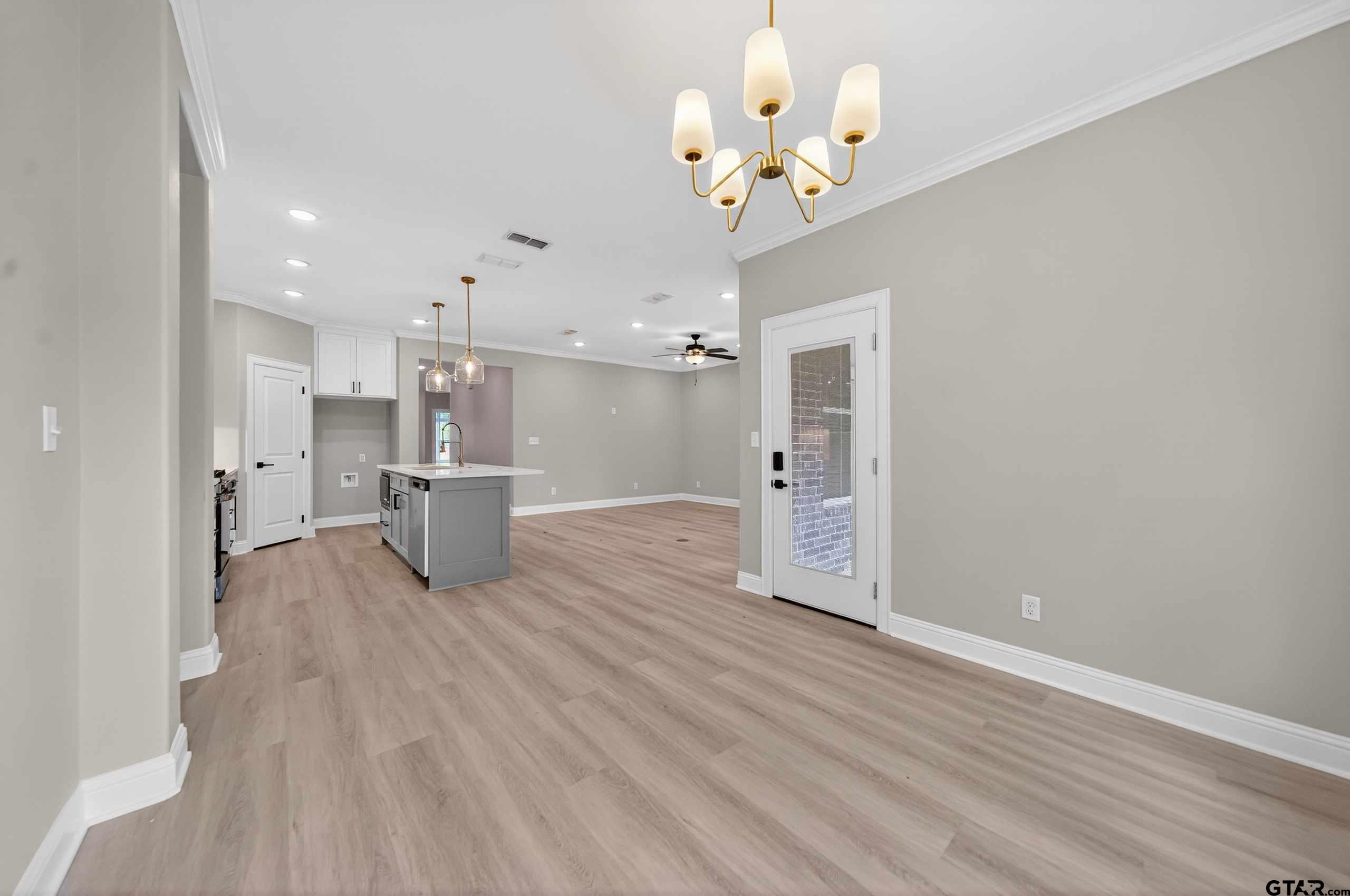 3049 Guinn Farms Road Tyler, TX 75707 - Photo 19 of 43 a view of a big room with wooden floor and a kitchen