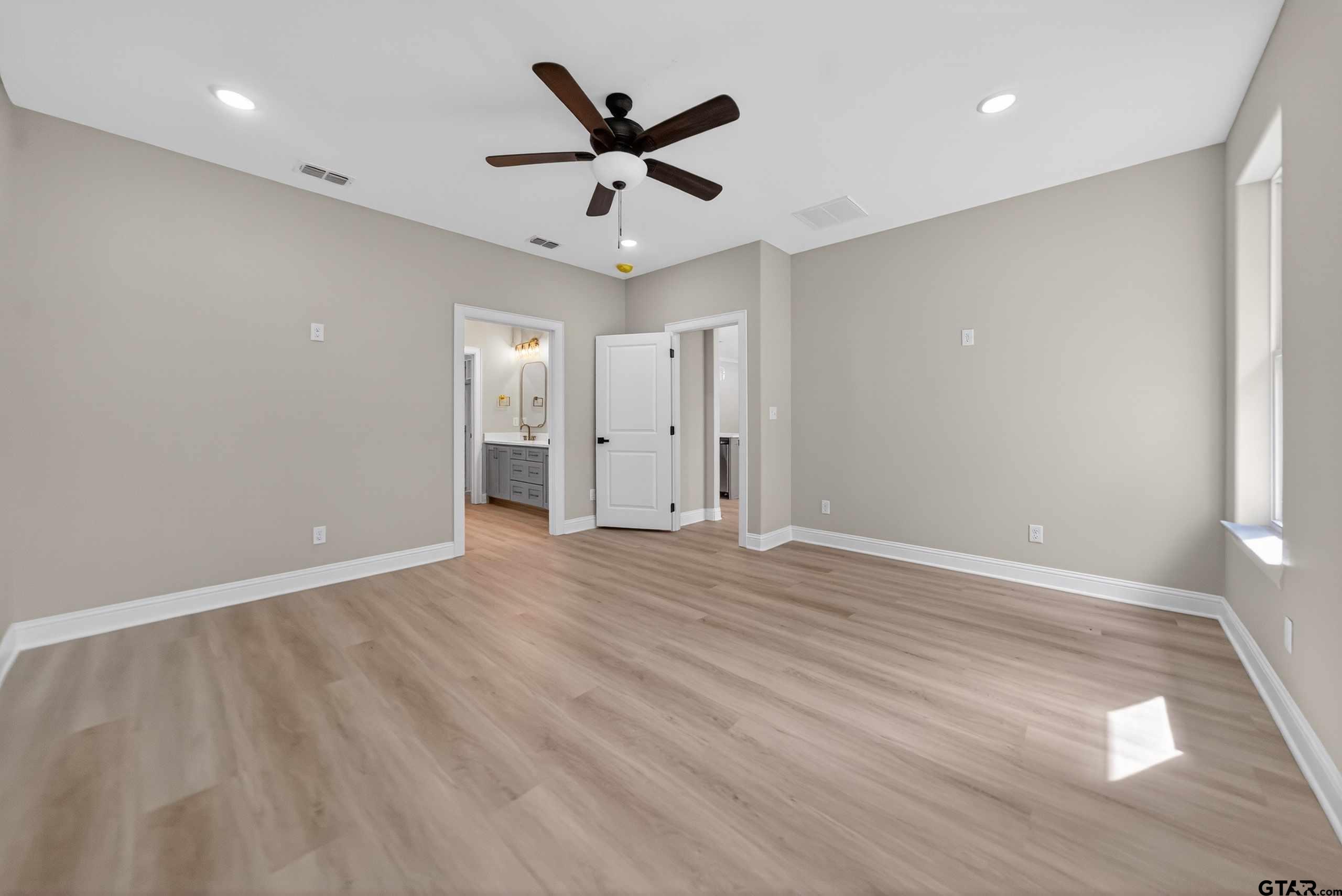 3049 Guinn Farms Road Tyler, TX 75707 - Photo 23 of 43 an empty room with wooden floor and a ceiling fan
