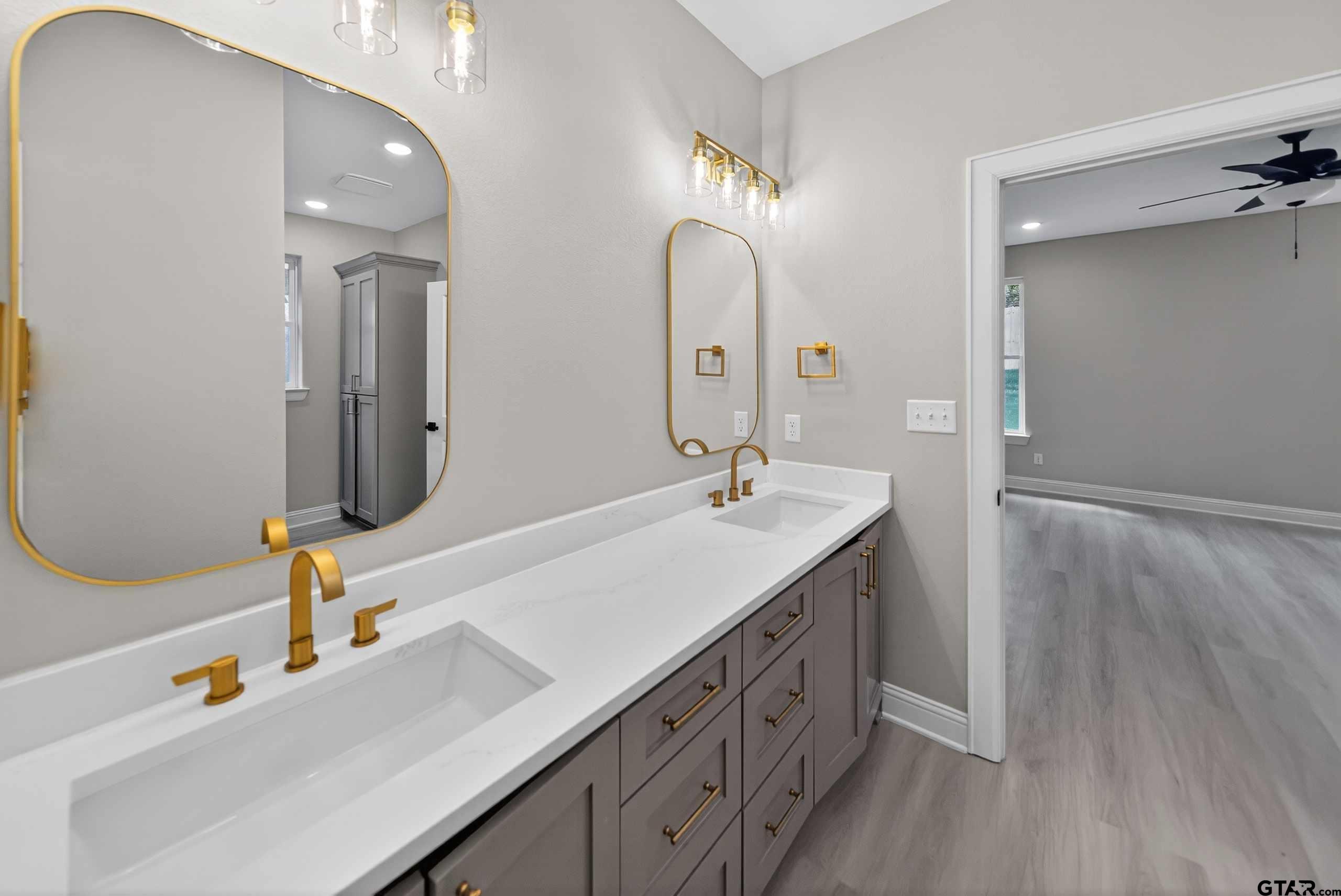 3049 Guinn Farms Road Tyler, TX 75707 - Photo 25 of 43 a bathroom with a double vanity sink and a mirror
