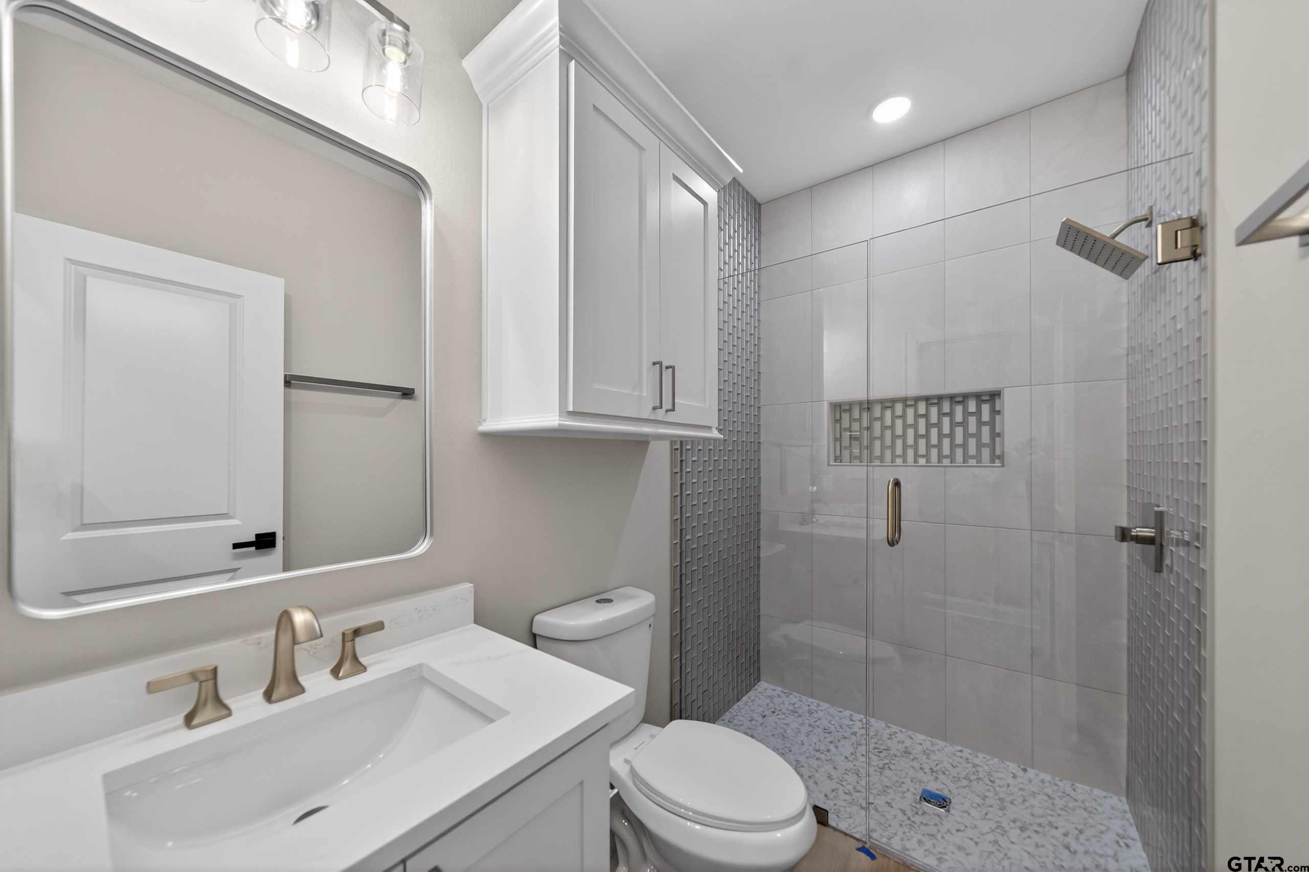 3049 Guinn Farms Road Tyler, TX 75707 - Photo 31 of 43 a bathroom with a sink toilet a mirror and shower