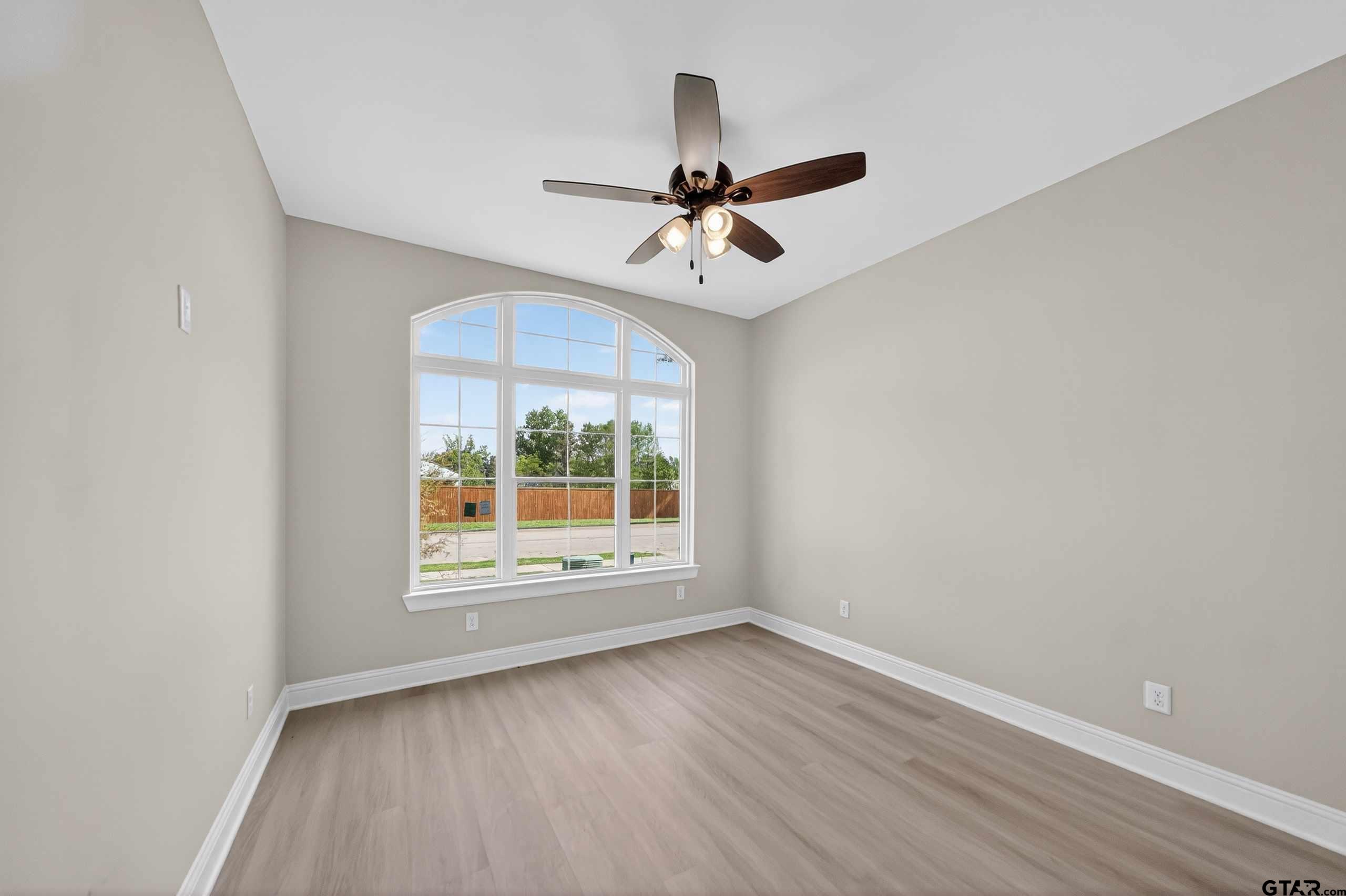 3049 Guinn Farms Road Tyler, TX 75707 - Photo 33 of 43 an empty room with wooden floor ceiling fan and windows